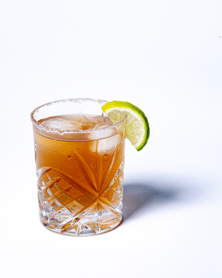 Electric Tamarita garnished in a glass with a salted rim and lime wedge